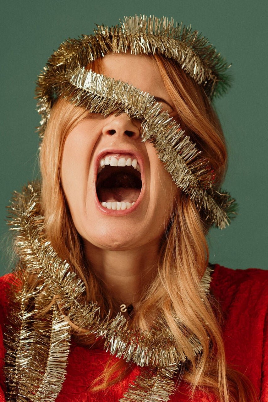 Woman screaming wrapped in tinsel Christmas load
