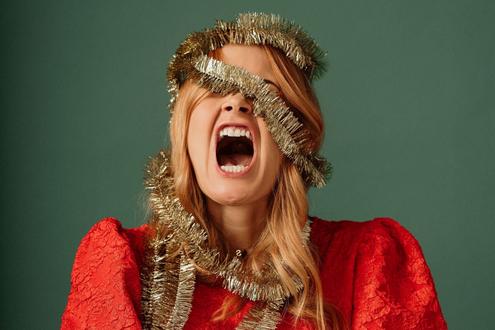 Woman screaming wrapped in tinsel Christmas load