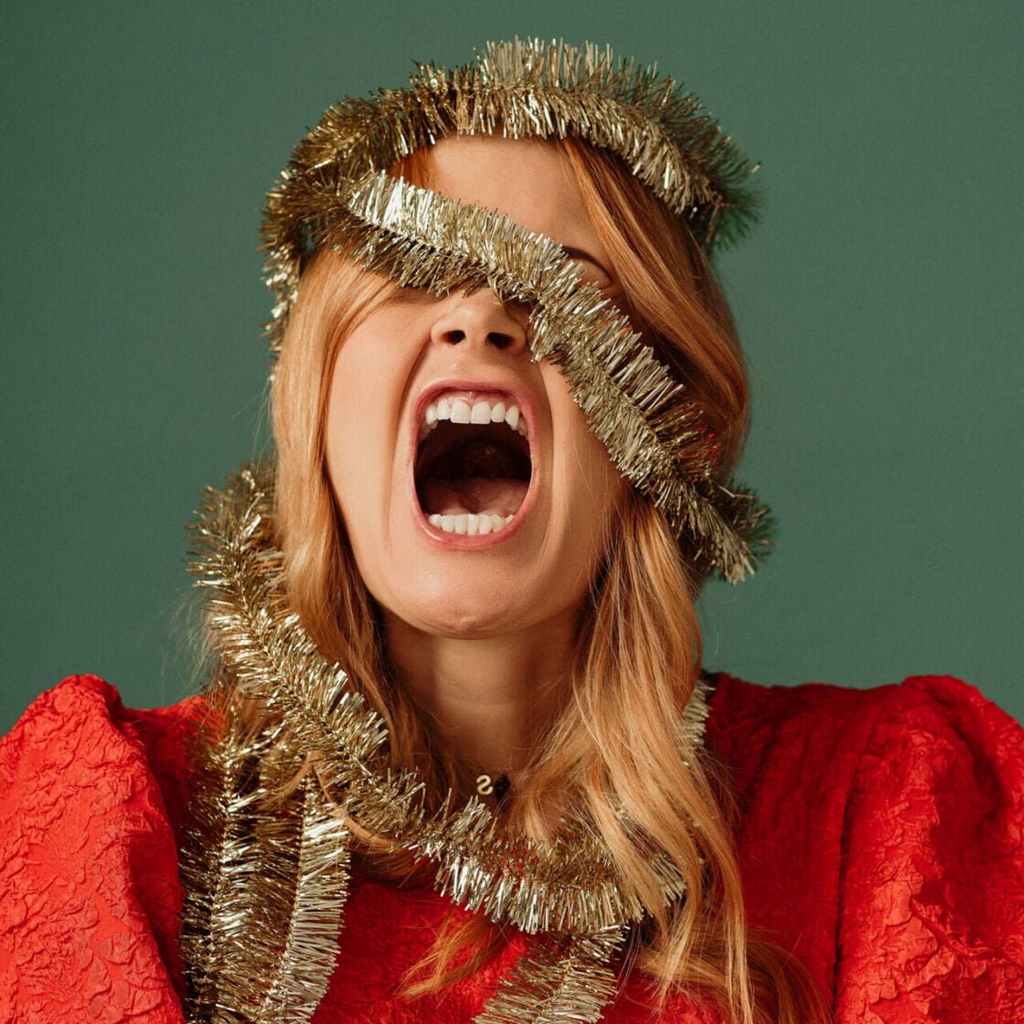 Woman screaming wrapped in tinsel Christmas load