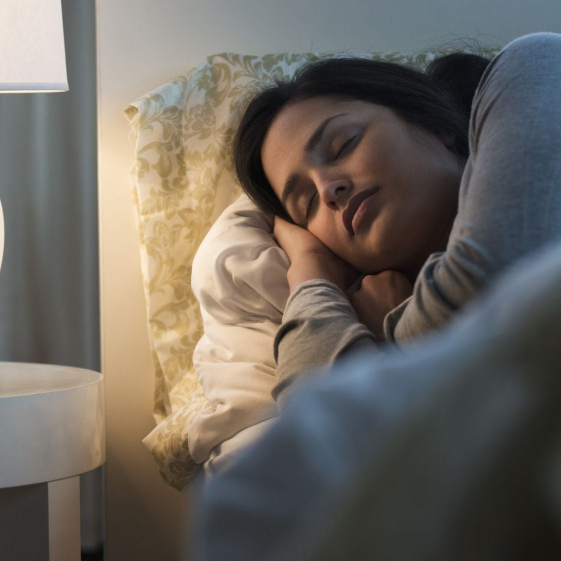 A woman fast asleep in bed at night