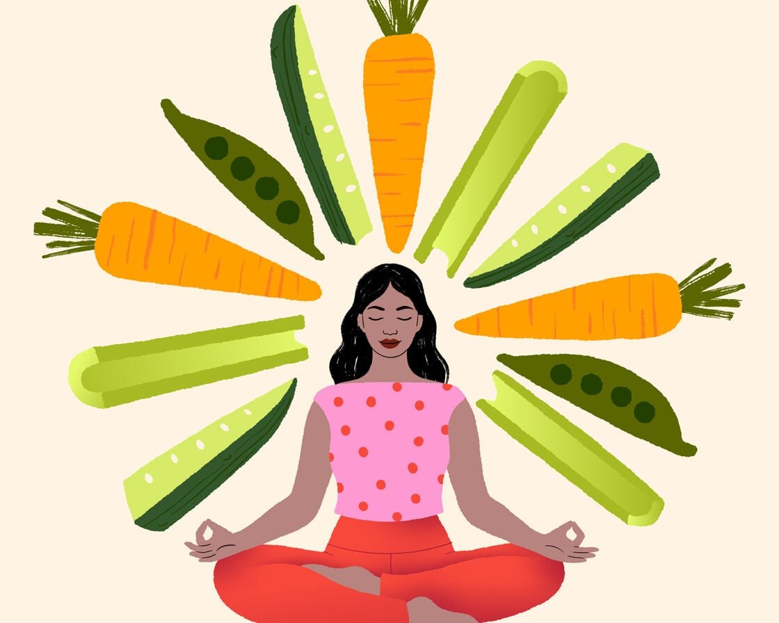 Image of a woman seated surrounded by vegetables