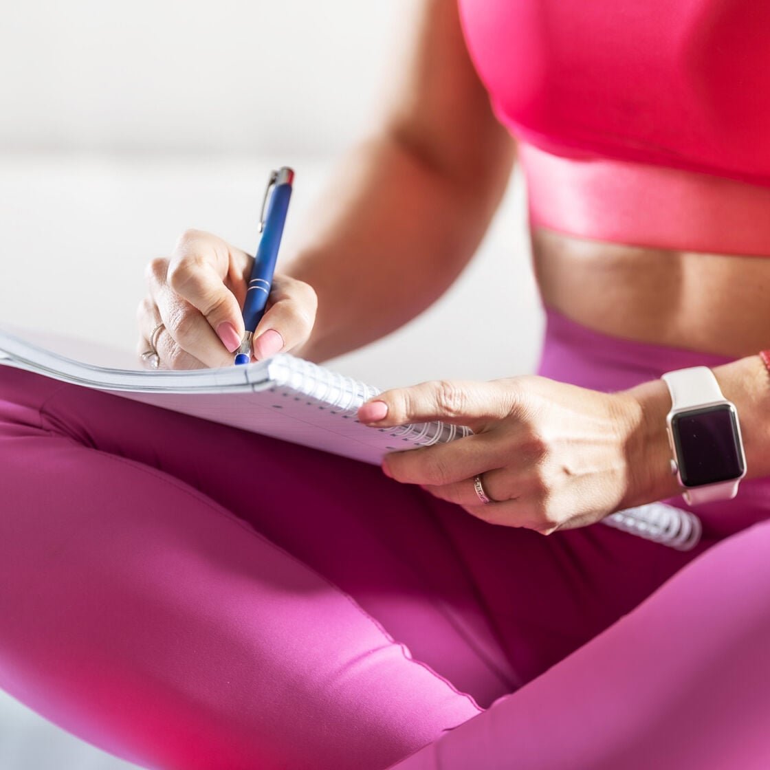 Woman writing out fitness goals