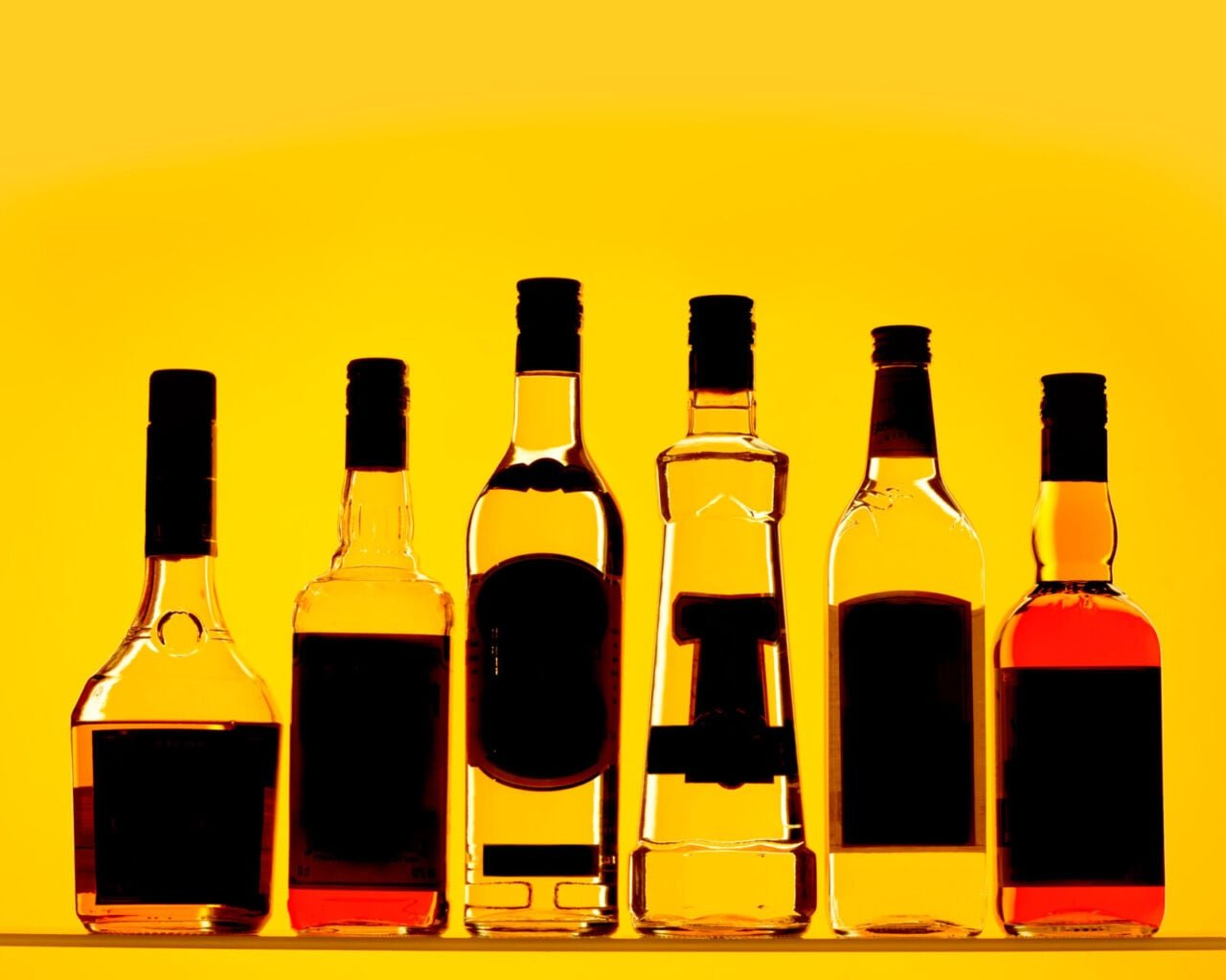 A selection of alcohol bottles on a yellow background